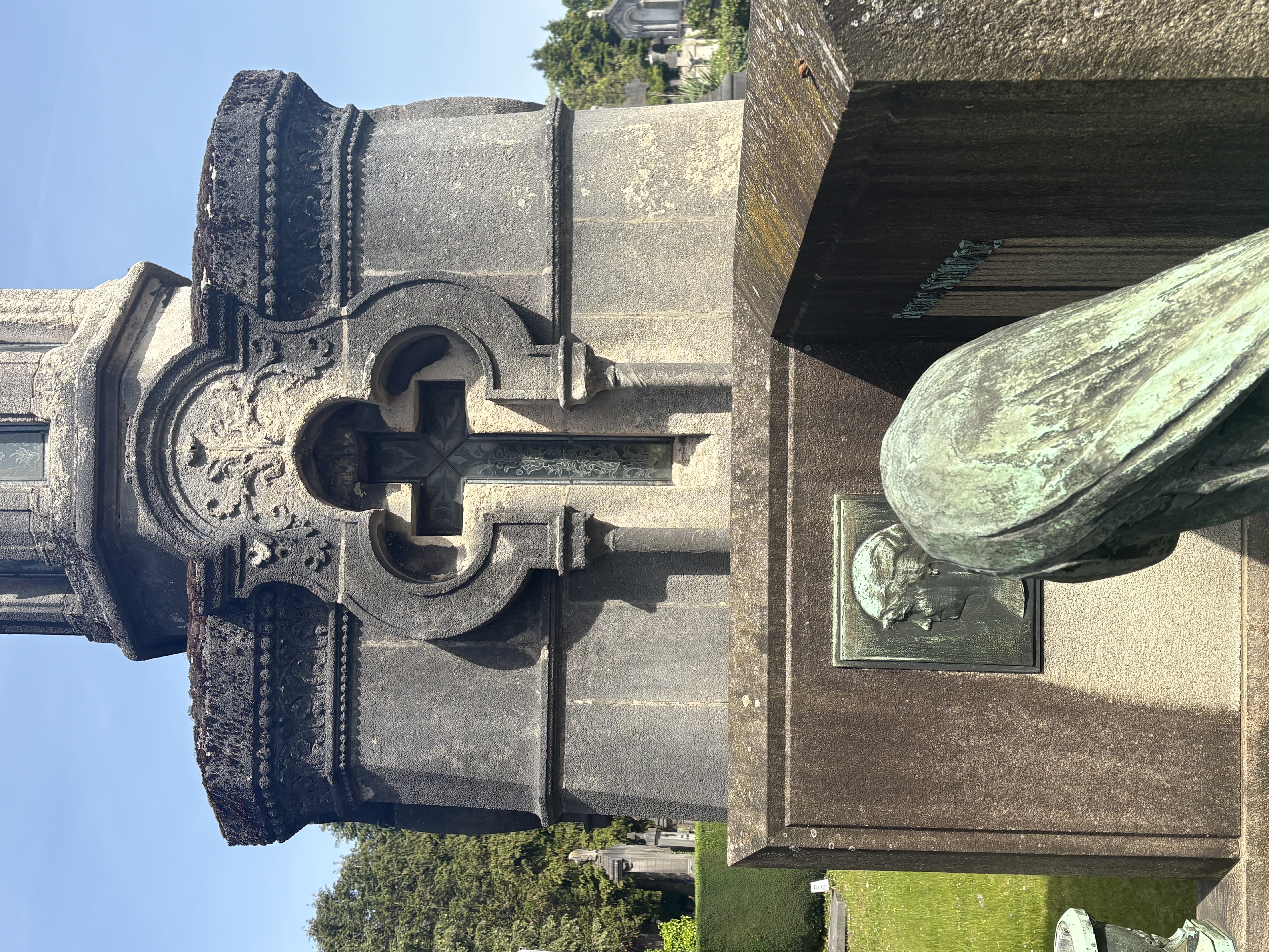 Monument funéraire avec croix ornée et sculpture en bronze