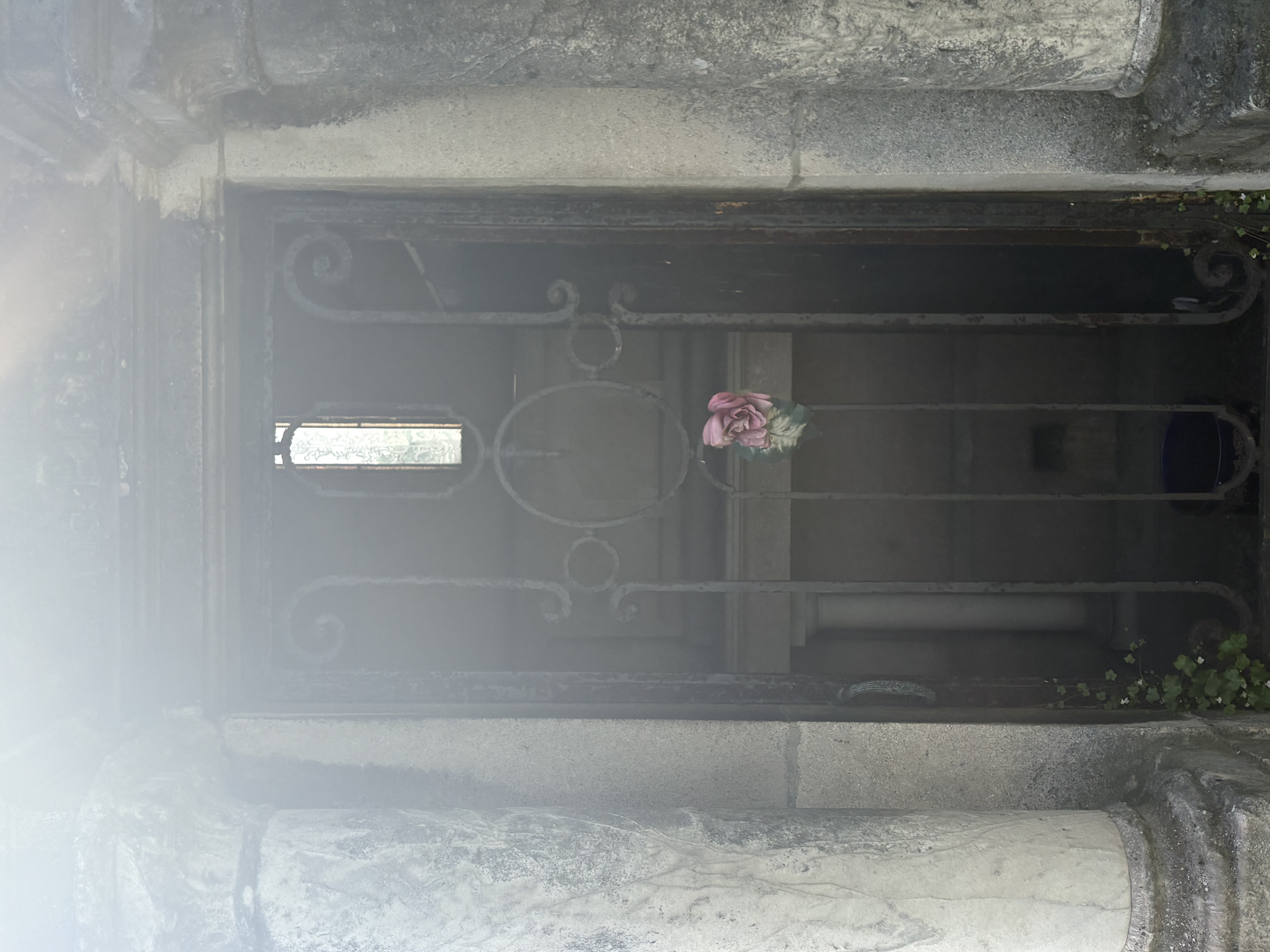 Chapelle funéraire avec porte en fer forgé et rose solitaire